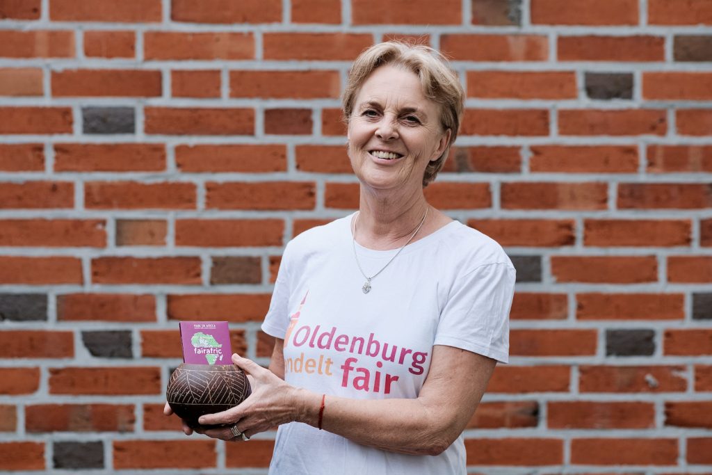Frau in T-Shirt mit dem Logo von Oldenburg handelt fair und fairer Schokolade in den Händen. Foto: © J. Bädeker