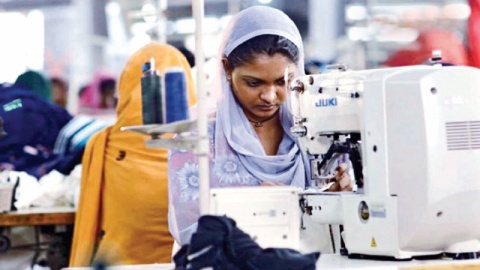 Eine Frau mit Kopftuch hinter einer Nähmaschine. Foto: © Filmfoto, Made in Bangladesh